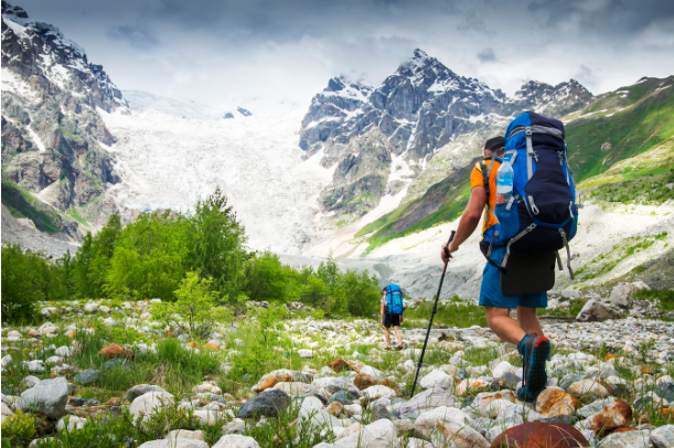 Two people hiking up a mountain glacier