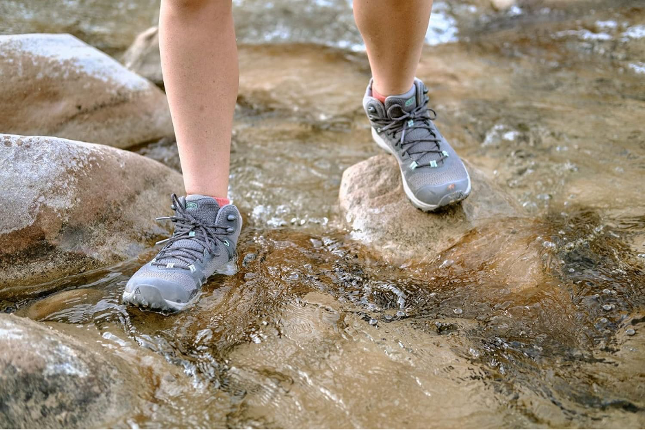 A person hiking on rocks in a river