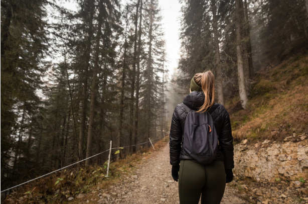 A woman hiking up a mountain trail.