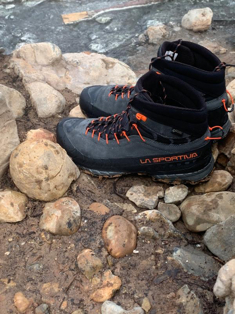 Hiking Boots on rocks by a river.