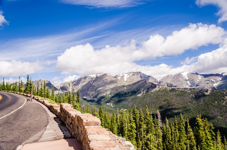 A road with trees and mountains in the background.