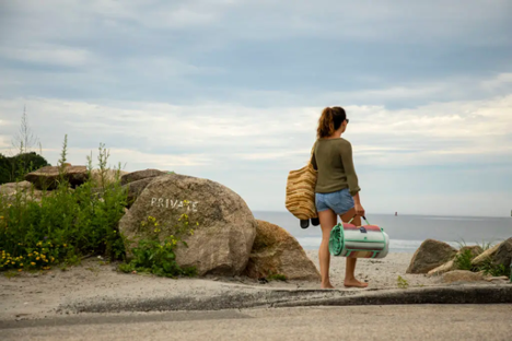 a person carrying a blanket on the beach