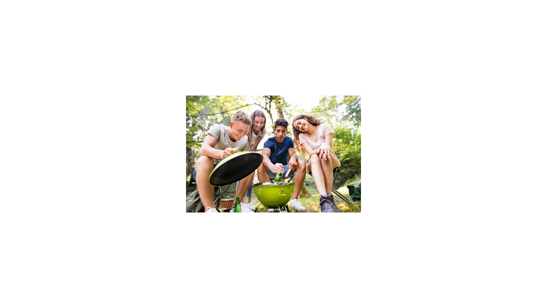 Kids sitting around a grill, cooking