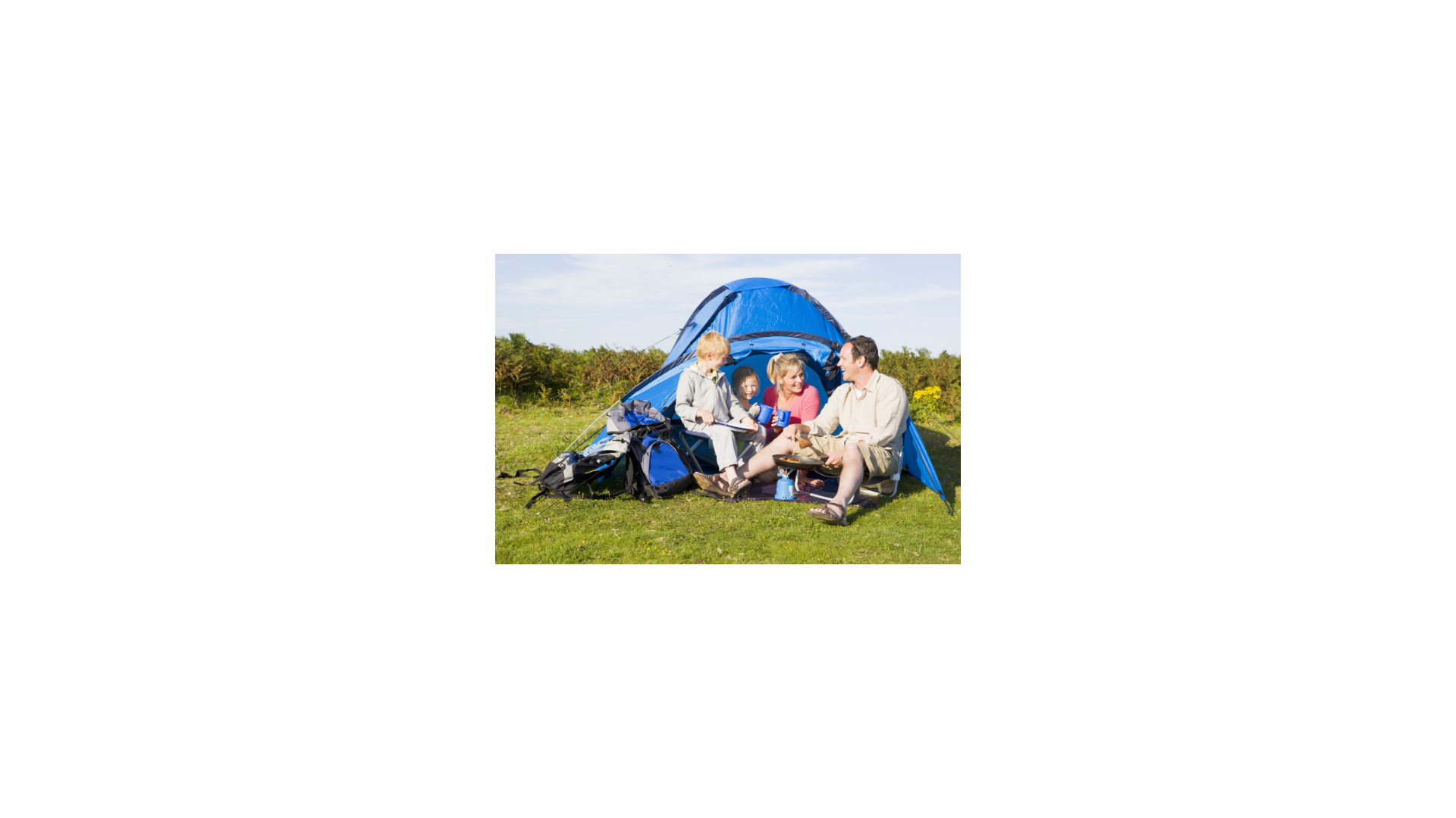 Family cooking breakfast sitting in front of a tent