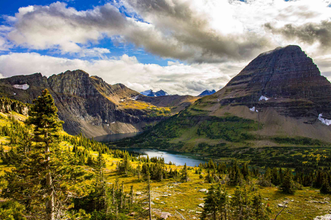 a mountain range with trees and a lake