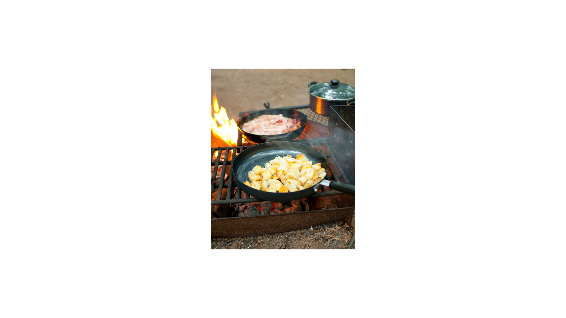 Potatos and meat cooking over campfire